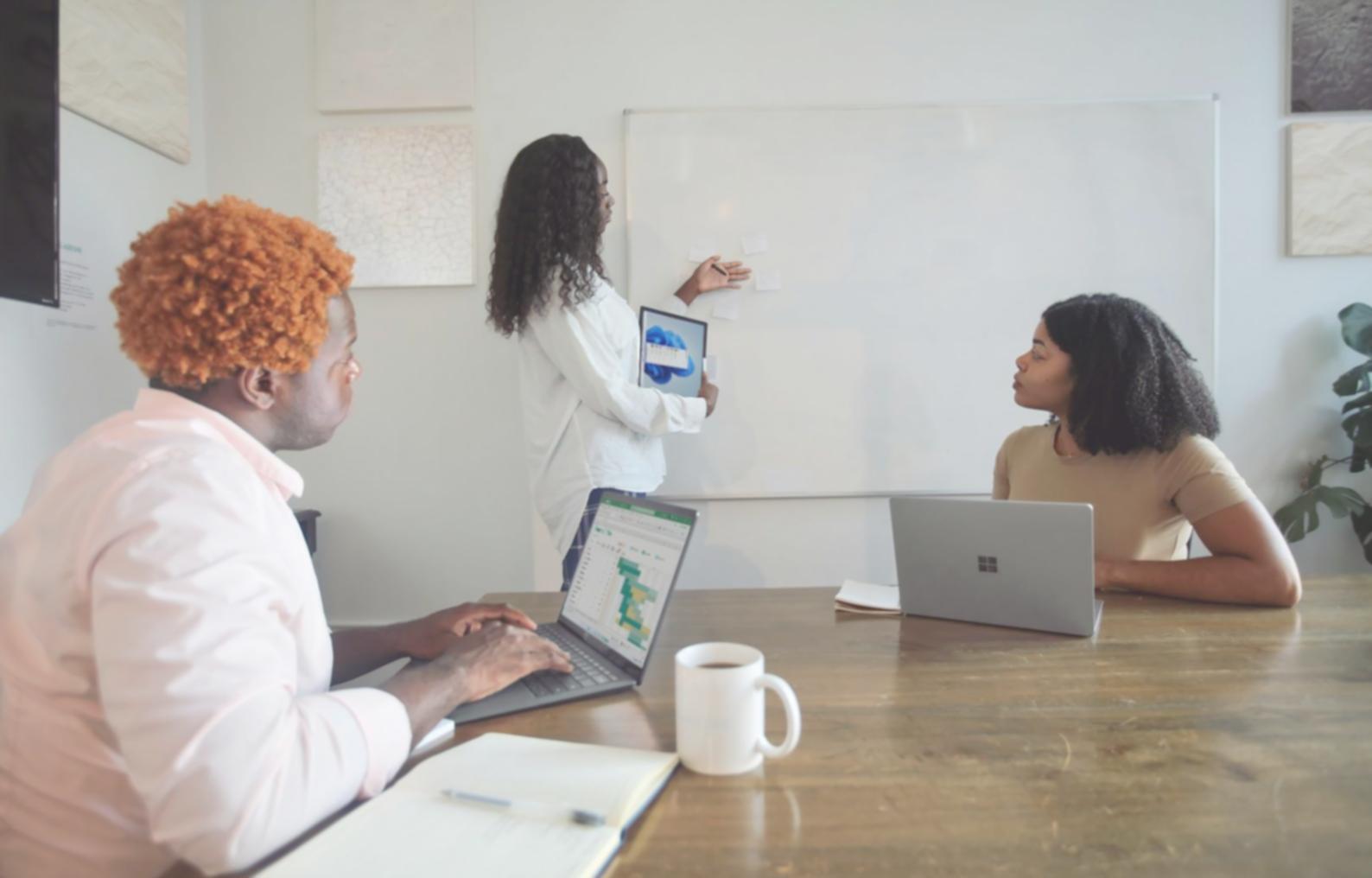 Business professionals collaborating around laptop displaying financial analytics and growth charts